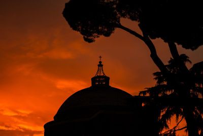 Low angle view of silhouette building against cloudy sky