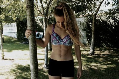 Young woman in sports clothing standing at park