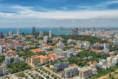 High angle view of city by sea against sky