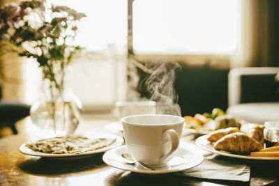 Hot coffee with meal served in breakfast on table at hotel room