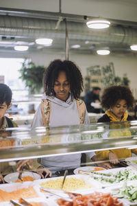 Students taking food during lunch break in cafeteria at school