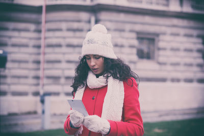 Woman using mobile phone in city