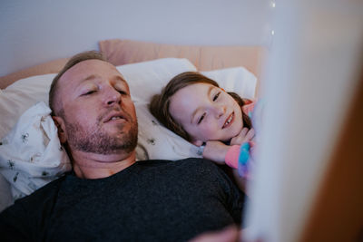 Close up of father reading to happy young daughter