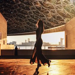 Side view of woman walking in building