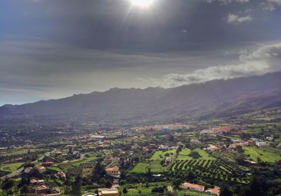 Aerial view of townscape and mountains against sky