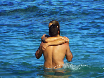 Couple embracing while standing at sea