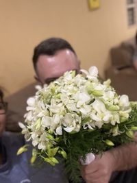 Midsection of man holding flower bouquet