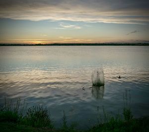 Splash in lake against sky during sunset