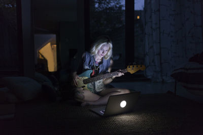 Beautiful young woman playing an electric guitar