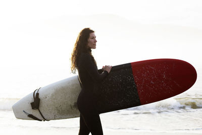 Beautiful, fit surfer girl in the pacific northwest