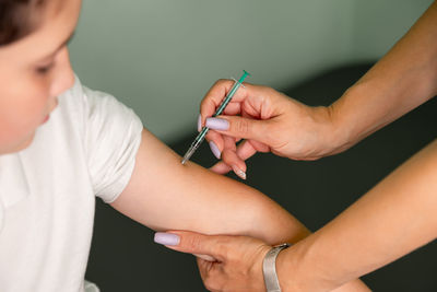 Nurse with syringe vaccinating child with anti-virus vaccine injection