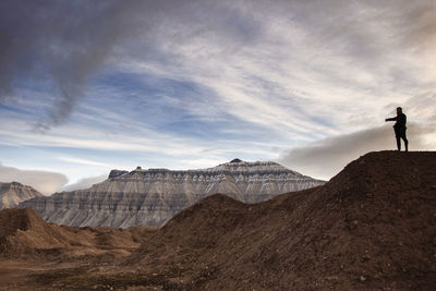 Man standing on mountain peak against sky