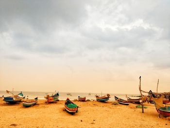 Boats moored on beach against sky