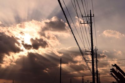 Low angle view of silhouette power lines against sky during sunset