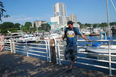 Full length of mature man standing at harbor against clear sky