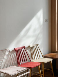 Empty chairs and table against wall at home