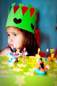 Close-up of girl by birthday cake