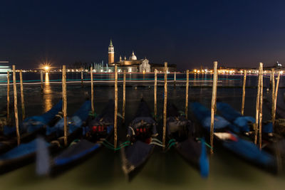 Blurred motion of gondolas moored on grand canal against st marks square at night