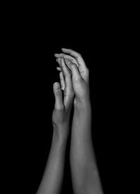 Close-up of woman hand against black background