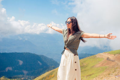 Portrait of young woman standing on mountain