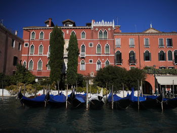 Boats moored in canal by building against sky in venezia, italy