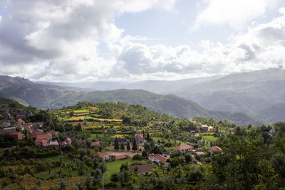 Scenic view of townscape and mountains against sky