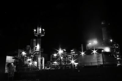 Low angle view of illuminated buildings against sky at night