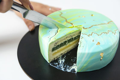 Close-up of hand holding leaf on cutting board