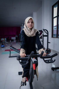 Portrait of young woman sitting in gym