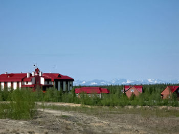 Houses on field against clear sky