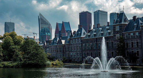 Fountain in city against sky