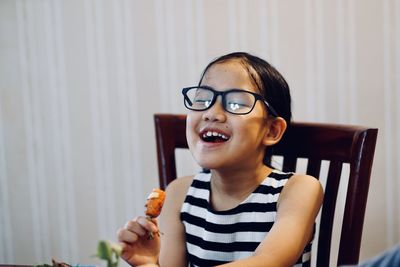 Close-up of boy making face at home