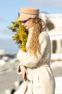 A  woman with a yellow acacia flowers. the concept of the spring - march 8, easter, women's day