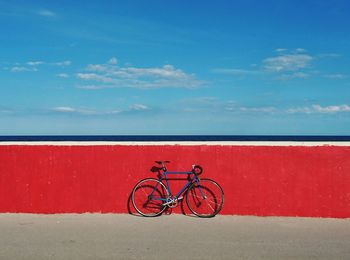 Bicycle against red wall