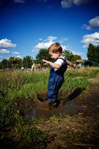 Rear view of girl standing on grassy field