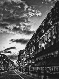Buildings in city against cloudy sky