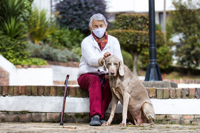 Portrait of man with dog sitting outdoors