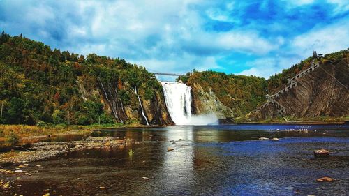 Scenic view of waterfall against sky