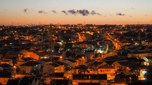 High angle view of illuminated cityscape against sky at sunset