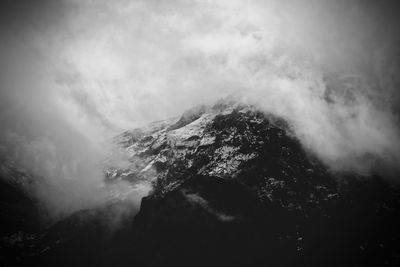 Low angle view of mountain against cloudy sky