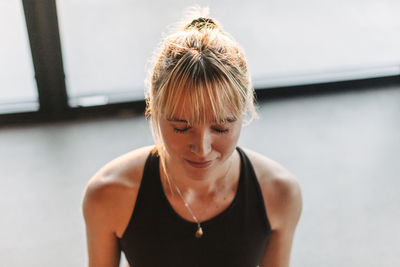 High angle view of woman meditating with eyes closed at retreat center