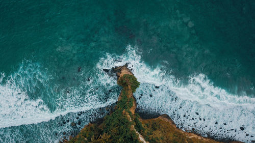 High angle view of wave splashing on rock