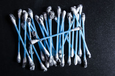 Close up of messy blue cotton swabs on black background