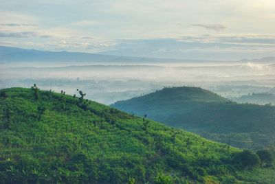 Scenic view of sea by mountains against sky