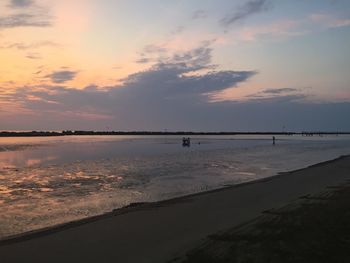 Scenic view of beach against sky during sunset