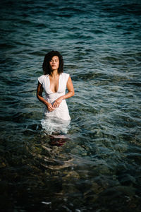 Woman wearing dress while standing in sea