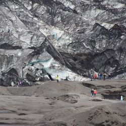 Group of people walking on mountain against sky