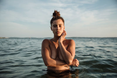 Portrait of young woman in sea against sky