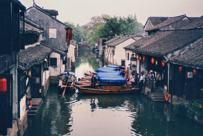 Boats in canal amidst buildings in city