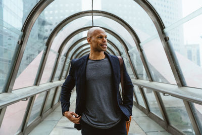 Portrait of young man standing against building